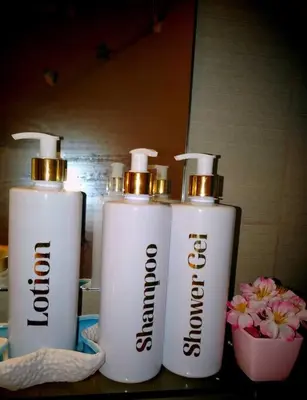 three bottles ofodorizers sitting on a counter with flowers at Azure staycationbyGetwellwander in Manila