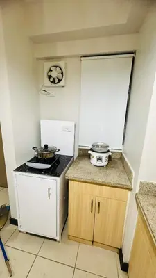 a kitchen with a stove and two pans on a counter at Resort-Style 2BR Condo at Alea DMCI Family Staycation in Manila