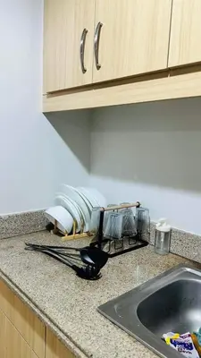 a kitchen counter with plates on a rack next to a sink at Resort-Style 2BR Condo at Alea DMCI Family Staycation in Manila