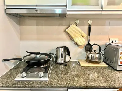 a kitchen counter with a stove with a pot on it at Deluxe Studio with Balcony at Greenbelt Makati Manila in Manila