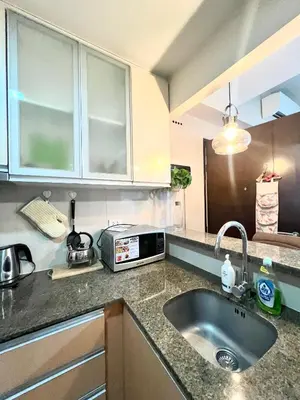 a kitchen with a sink and a microwave at Deluxe Studio with Balcony at Greenbelt Makati Manila in Manila