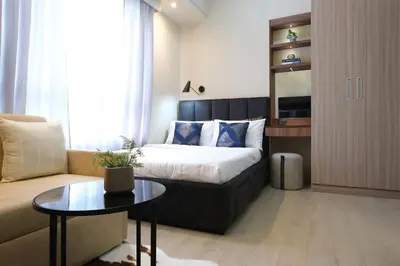 a bedroom with a bed and a couch and a table at Amelia's Crib at The Verdin in General Trias