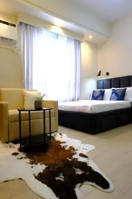a living room with a couch and a bed and a rug at Amelia's Crib at The Verdin in General Trias