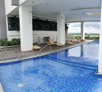 a large swimming pool with chairs in a building at Amelia's Crib at The Verdin in General Trias