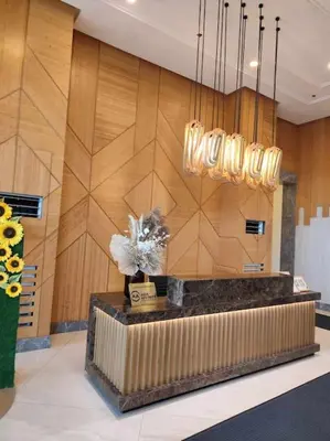 a lobby with a reception desk with a chandelier at Amelia's Crib at The Verdin in General Trias