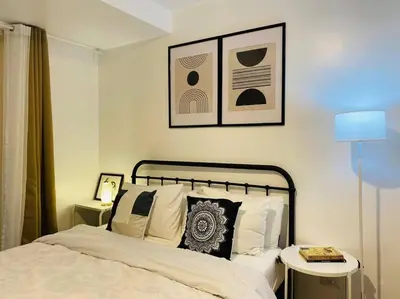 a bedroom with a bed and two tables with lamps at Park Mckinley West 1BR Balcony near BGC Makati Airport in Manila