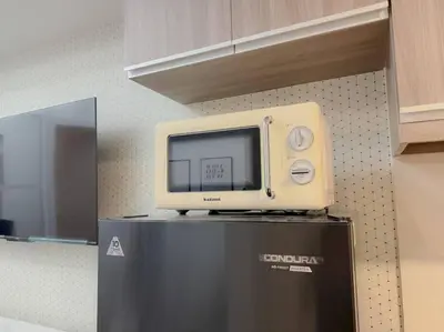 a microwave sitting on top of a refrigerator at Park Mckinley West 1BR Balcony near BGC Makati Airport in Manila