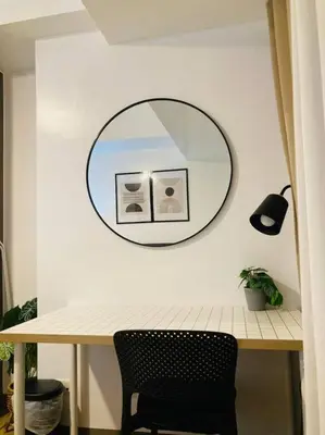 a mirror on a wall above a table with a chair at Park Mckinley West 1BR Balcony near BGC Makati Airport in Manila