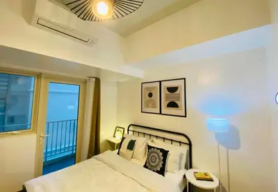 a bedroom with a bed with a view of the ocean at Park Mckinley West 1BR Balcony near BGC Makati Airport in Manila