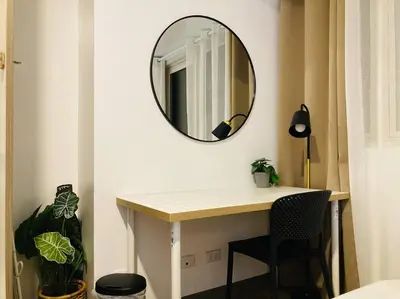 a mirror on a wall above a desk in a room at Park Mckinley West 1BR Balcony near BGC Makati Airport in Manila