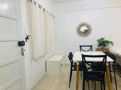 a dining room with a white table and black chairs at 2 Bedroom with Resort Facilities near BGC and Makati in Manila