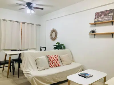 a living room with a white couch and a table at 2 Bedroom with Resort Facilities near BGC and Makati in Manila