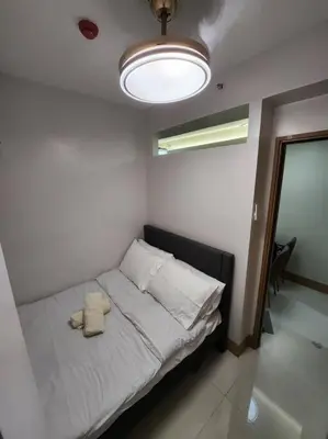 a small bed in a room with a light at Mocha Flat at Shore 3 Tower 4 in Manila