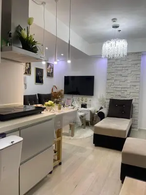 a kitchen and living room with a table and a couch at DT Suites and Resorts at Azure Paranaque in Manila