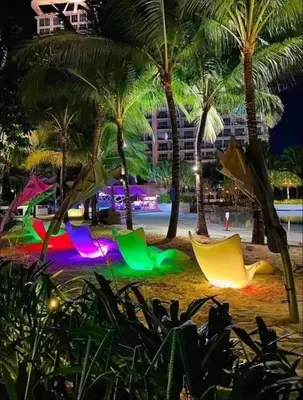 a beach at night with palm trees and colored lights at DT Suites and Resorts at Azure Paranaque in Manila