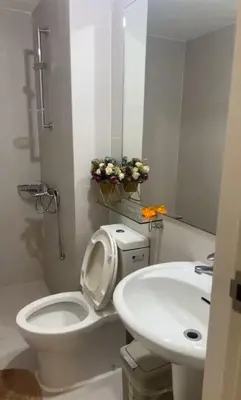 a white bathroom with a toilet and a sink at DT Suites and Resorts at Azure Paranaque in Manila