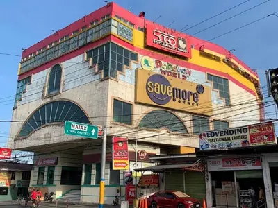 a building with signs on it on a city street at Hotel Sogo Bacoor in Bacoor