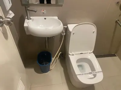 a bathroom with a toilet and a sink at Hotel Sogo Bacoor in Bacoor