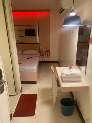 a small room with a bed and a table in it at Hotel Sogo Bacoor in Bacoor