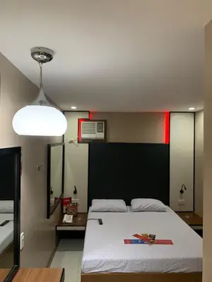 a bedroom with a large white bed and a light at Hotel Sogo Bacoor in Bacoor