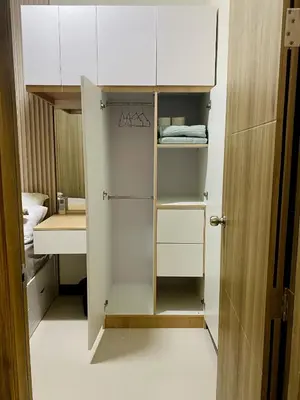 a closet with white cabinets and a sink in a room at Coast Residences condo near MOA, StarCity and PICC in Manila