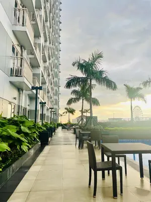 a corridor of a building with tables and chairs at Coast Residences condo near MOA, StarCity and PICC in Manila