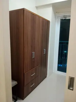 a large wooden cabinet in a room with a window at Jazz staycation in Manila