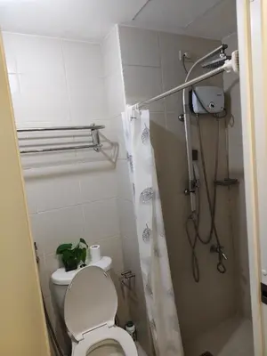 a small bathroom with a toilet and a shower at Jazz staycation in Manila