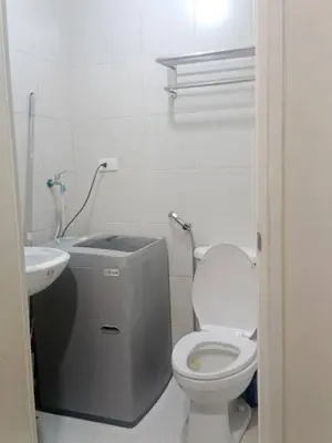 a white bathroom with a toilet and a sink at Jazz staycation in Manila