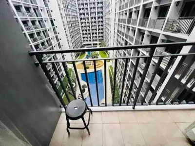 a chair sitting on a balcony with tall buildings at 1 BR Apartment near SM Mall of Asia, Airport, Manila in Manila