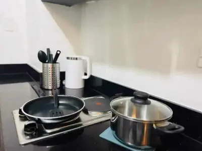 a stove top with two pots and pans on it at 1 BR Apartment near SM Mall of Asia, Airport, Manila in Manila