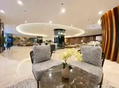 a lobby with two chairs and a table with flowers on it at 1 BR Apartment near SM Mall of Asia, Airport, Manila in Manila