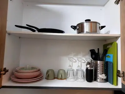 a shelf with dishes and utensils in a kitchen at 1 BR Apartment near SM Mall of Asia, Airport, Manila in Manila