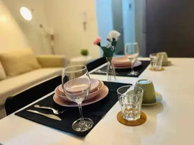 a table with plates and glasses on top of it at 1 BR Apartment near SM Mall of Asia, Airport, Manila in Manila