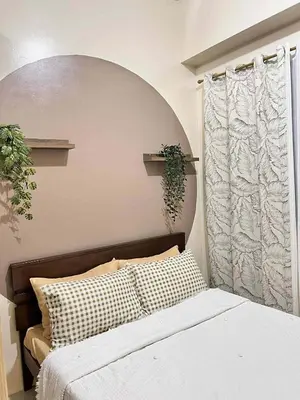 a bedroom with a bed and a window with a plant at Espacio Tres in Manila