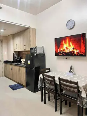 a kitchen with a table and a fire in the wall at Espacio Tres in Manila