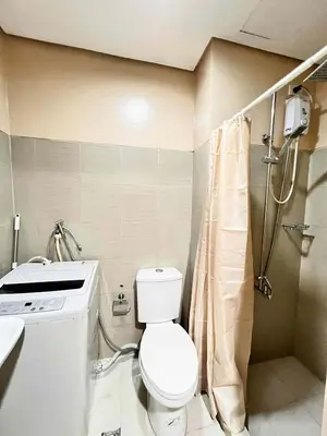 a small bathroom with a toilet and a shower at Espacio Tres in Manila