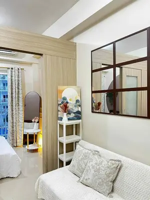 a bedroom with a bed and a mirror on the wall at Espacio Tres in Manila