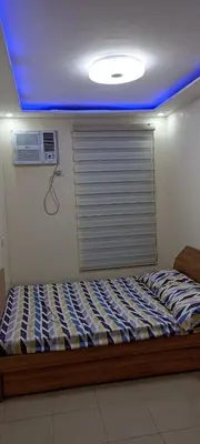 a bed in a room with a blue ceiling at Two bed room unit with parking space in Manila