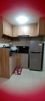 a kitchen with wooden cabinets and a stainless steel refrigerator at Two bed room unit with parking space in Manila