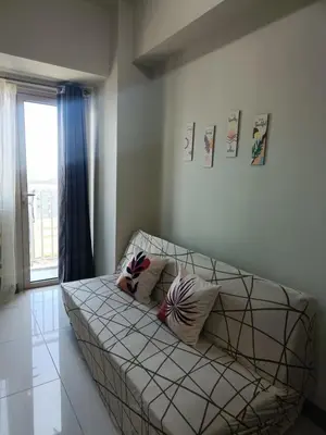 a white couch in a room with a window at Coast Residences-Ronnzel staycation in Manila