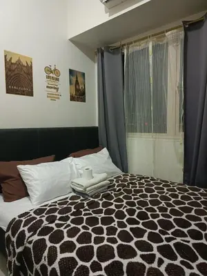 a bedroom with a black and white bed and a window at Coast Residences-Ronnzel staycation in Manila