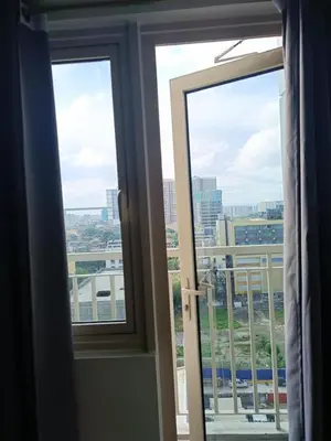 a window with a view of a city at Coast Residences-Ronnzel staycation in Manila
