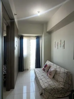 a living room with a couch and a window at Coast Residences-Ronnzel staycation in Manila