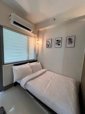 a small bedroom with a bed and a window at BALAY MULANO at FAME RESIDENCES MANDALUYONG CITY l with balcony pool view l 200mbps wifi in Manila