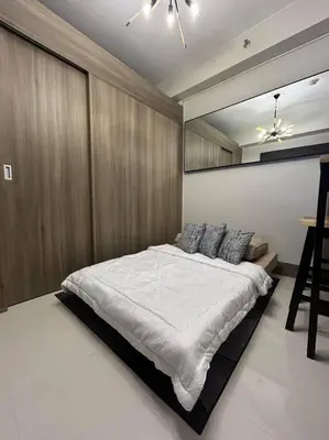 a bedroom with a large bed in a room at BALAY MULANO at FAME RESIDENCES MANDALUYONG CITY l with balcony pool view l 200mbps wifi in Manila
