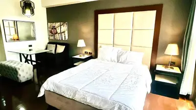 a bedroom with a large white bed and a desk at 9D Standard Room staycation in Manila