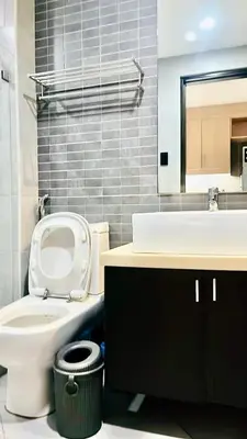 a bathroom with a toilet and a sink and a mirror at 9D Standard Room staycation in Manila