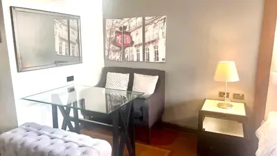 a living room with a glass table and a chair at 9D Standard Room staycation in Manila