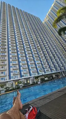 a dog is sitting in front of a large building at That Boho Crib 1bedroom with Balcony facing amenities in Manila